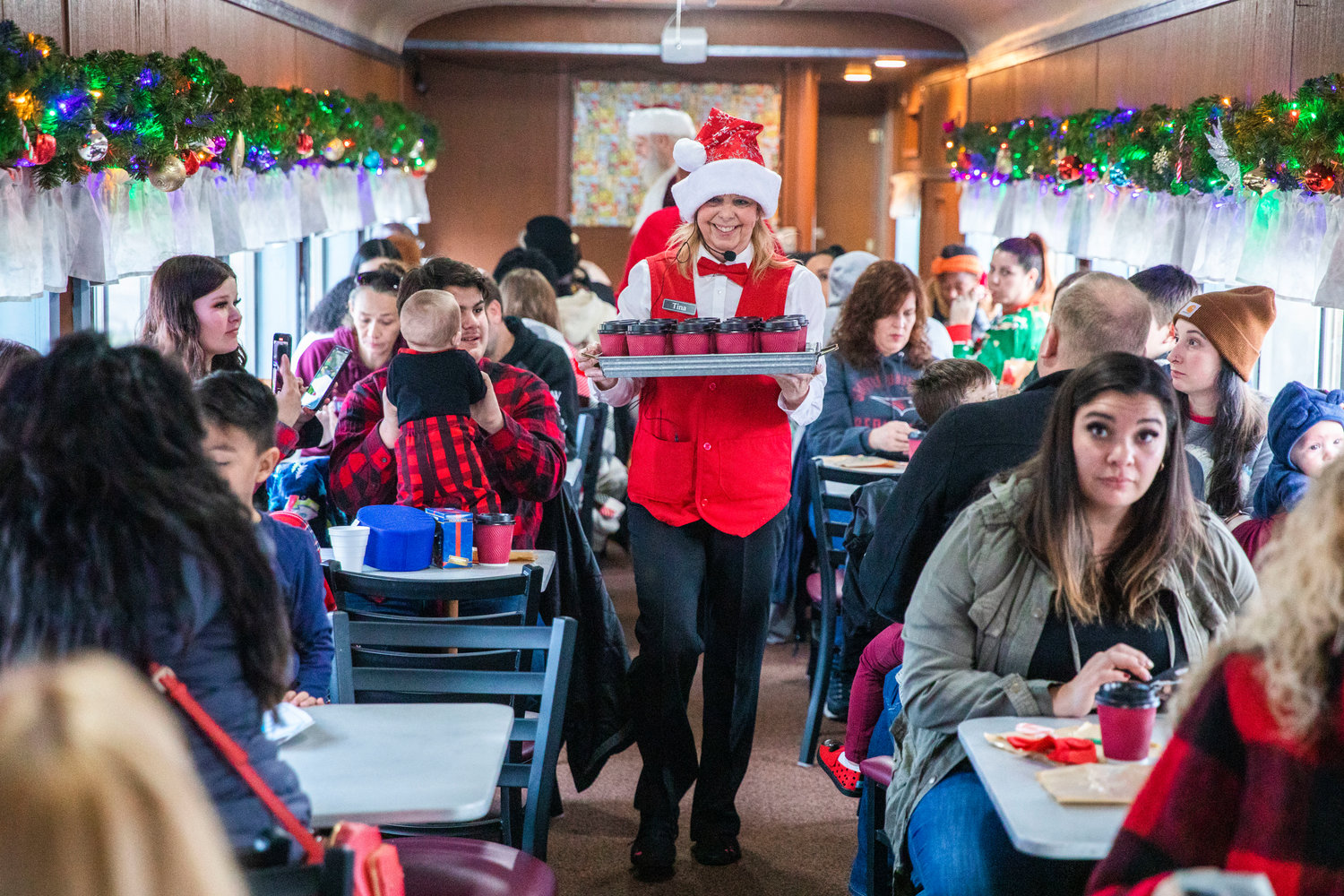 Hot cocoa is served with a smile as Santa visits passengers at the Steam Train Depot in Chehalis on Saturday.