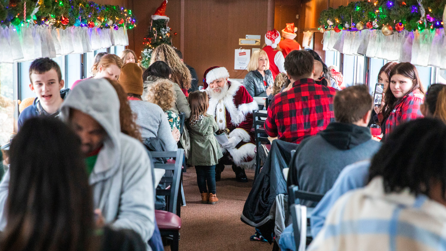Santa talks to kids while strolling through a 1920s passenger car at the Steam Train Depot in Chehalis on Saturday.