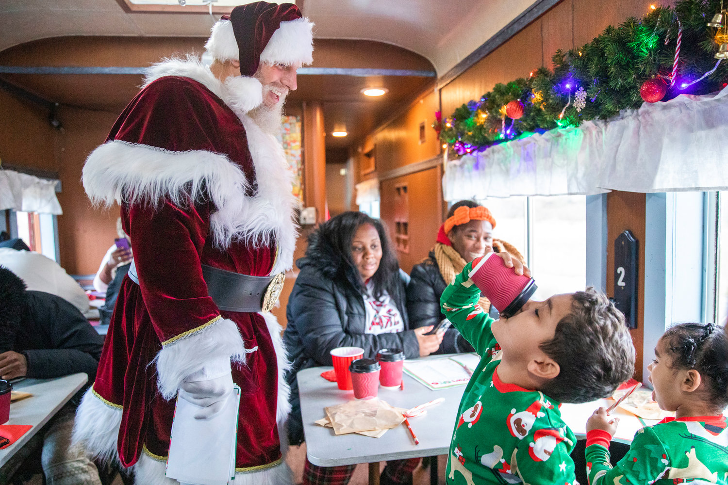 Santa laughs while visiting kids at the Steam Train Depot in Chehalis on Saturday.