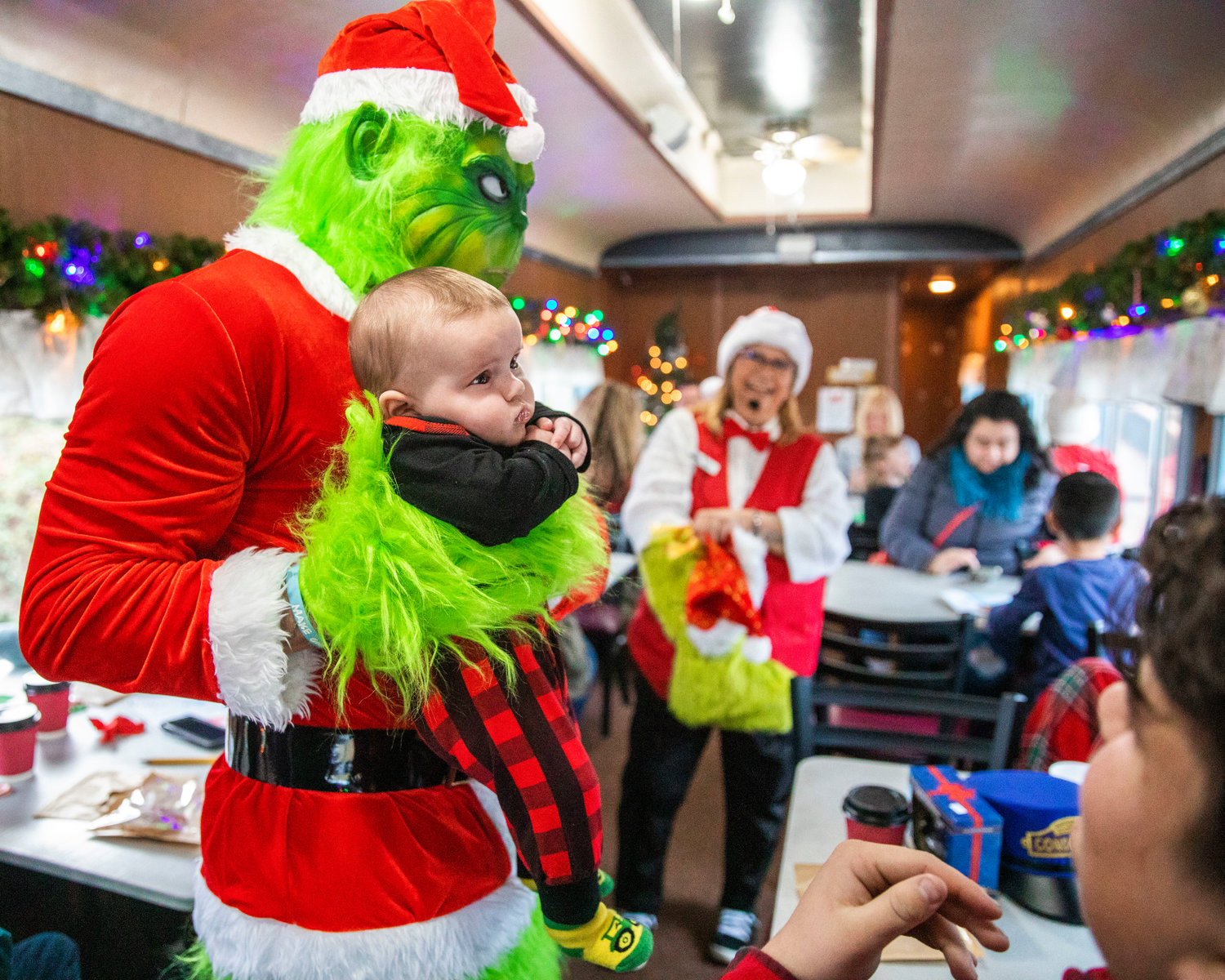The Grinch poses for a photo with 4-month-old Paxton at the Steam Train Depot in Chehalis on Saturday.