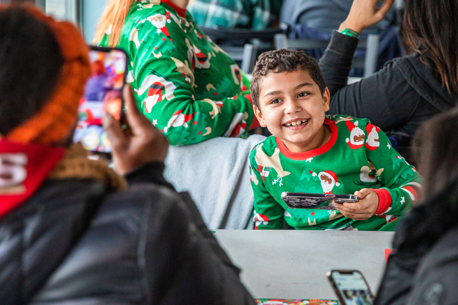 Kids smile while sporting Christmas pajamas before meeting Santa at the Steam Train Depot in Chehalis on Saturday.