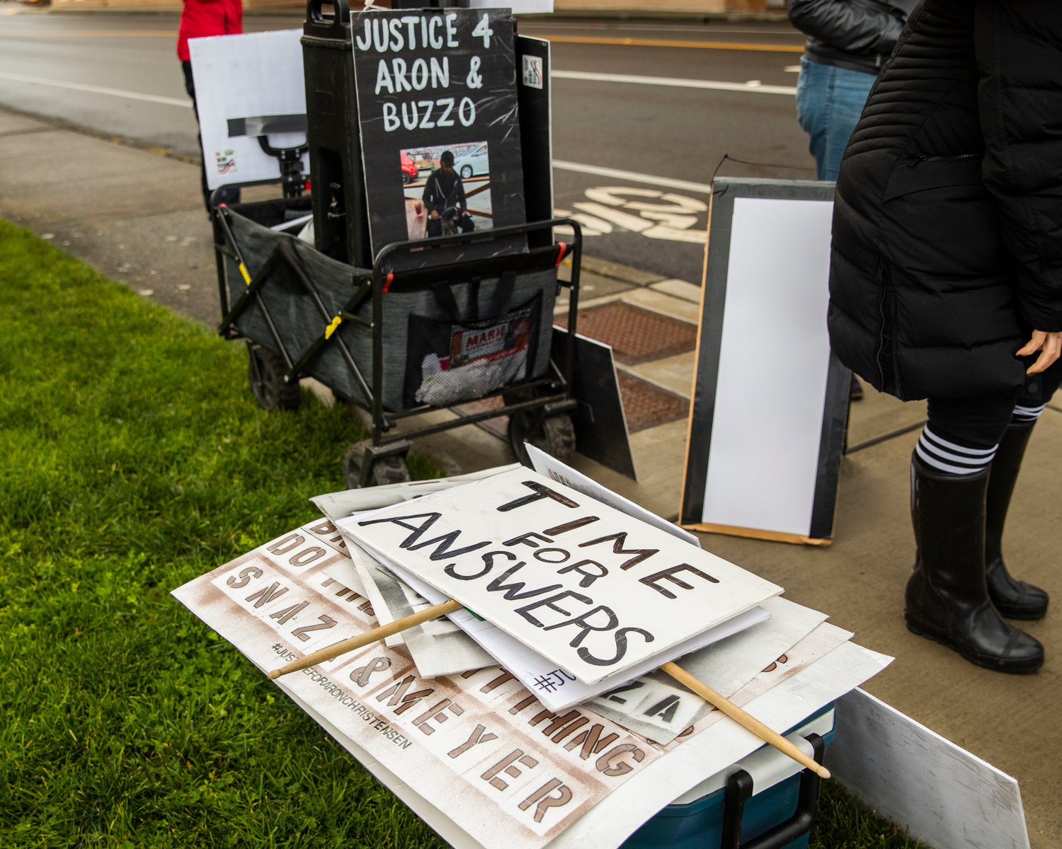 A sign reads “Time for answers,” as protesters stand outside the Lewis County Courthouse in Chehalis on Sunday demanding justice for Aron Christensen and his dog Buzzo.