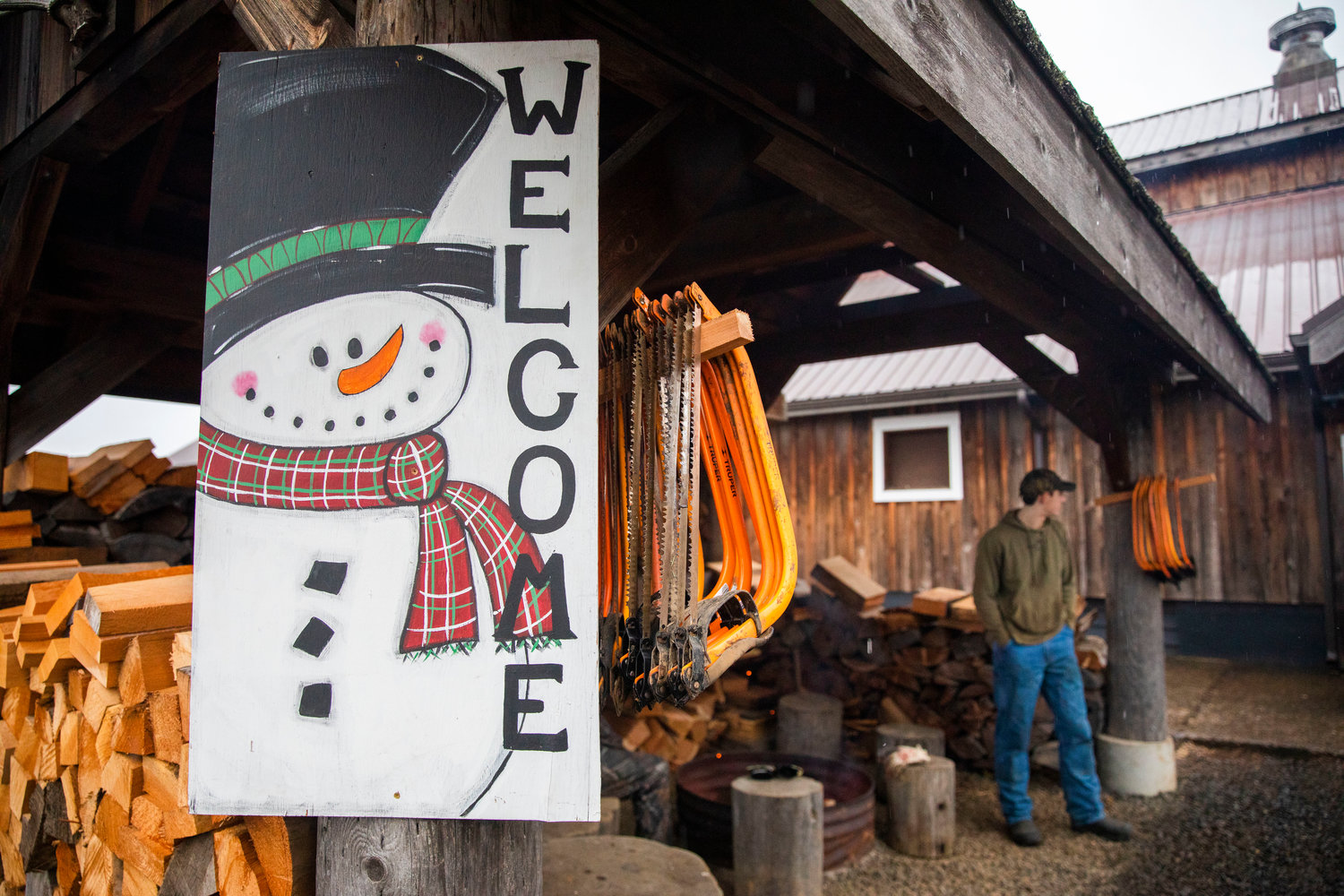 Saws hang next to a sign that welcomes visitors to the Mistletoe Tree Farm on Friday.