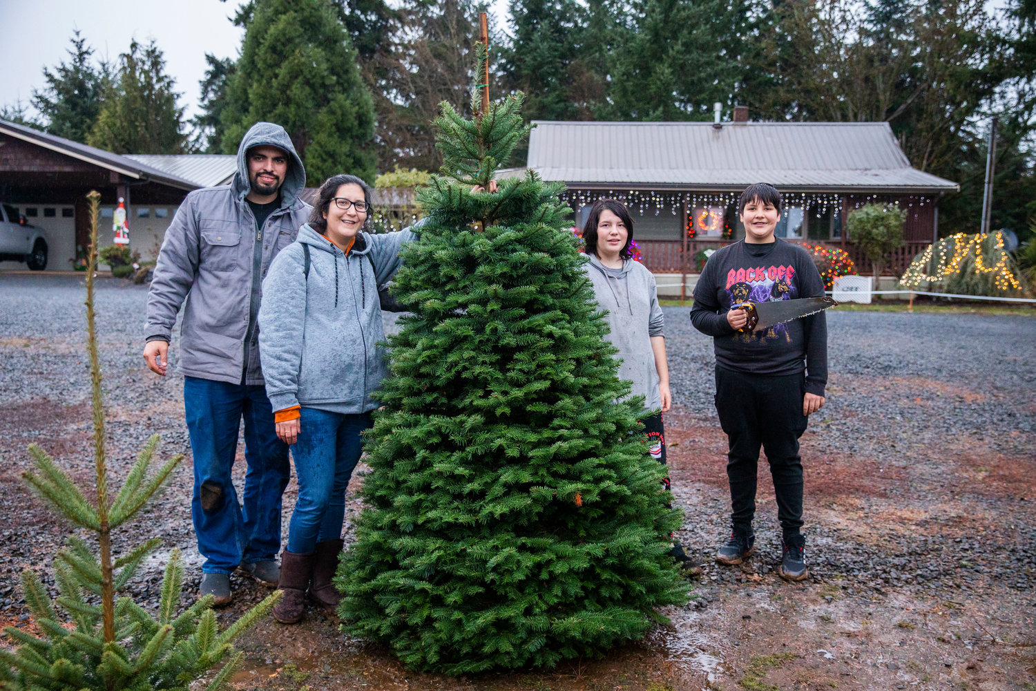 From left, Tyler Nunez, Winona Gladue, Lily, 13, and Michael Gladue, 12, smile for a photo after finding a tree at the Mistletoe Tree Farm west of Chehalis on Friday.