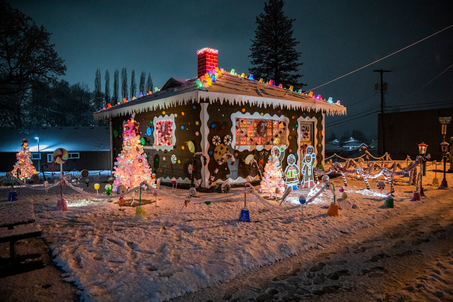 The locally famous Gingerbread House along Market Boulevard is illuminated in Chehalis Sunday night while surrounded by snow.