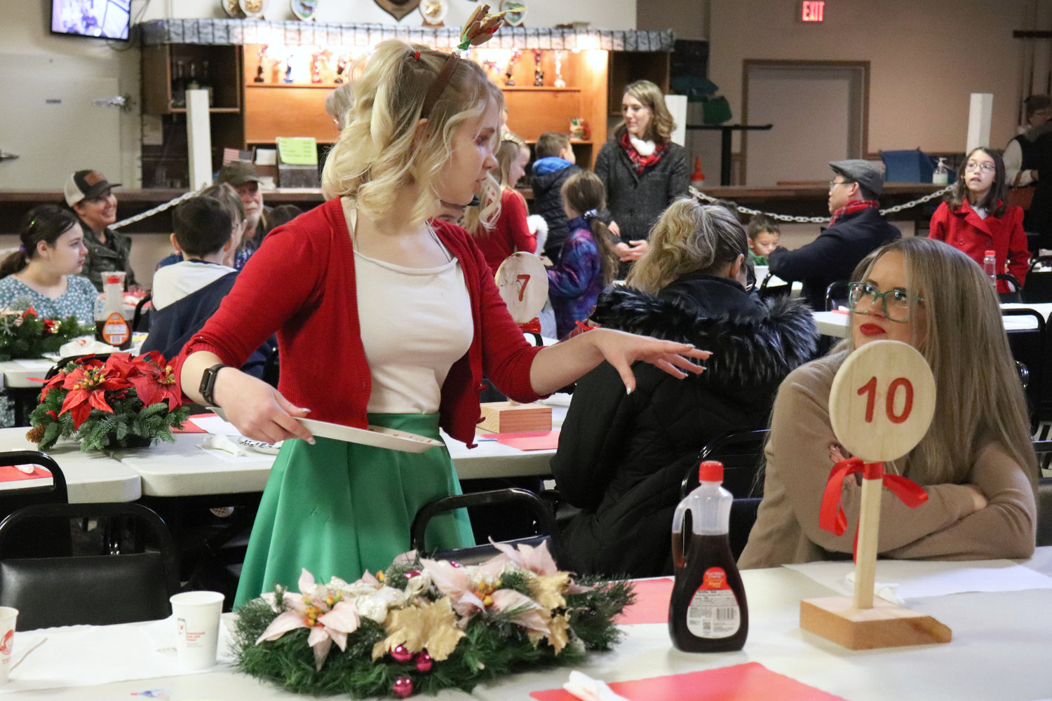 Volunteers serve plates of pancakes, scrambled eggs, sausage and applesauce during a Breakfast with Santa event at the Moose Family Center in Centralia on Saturday.