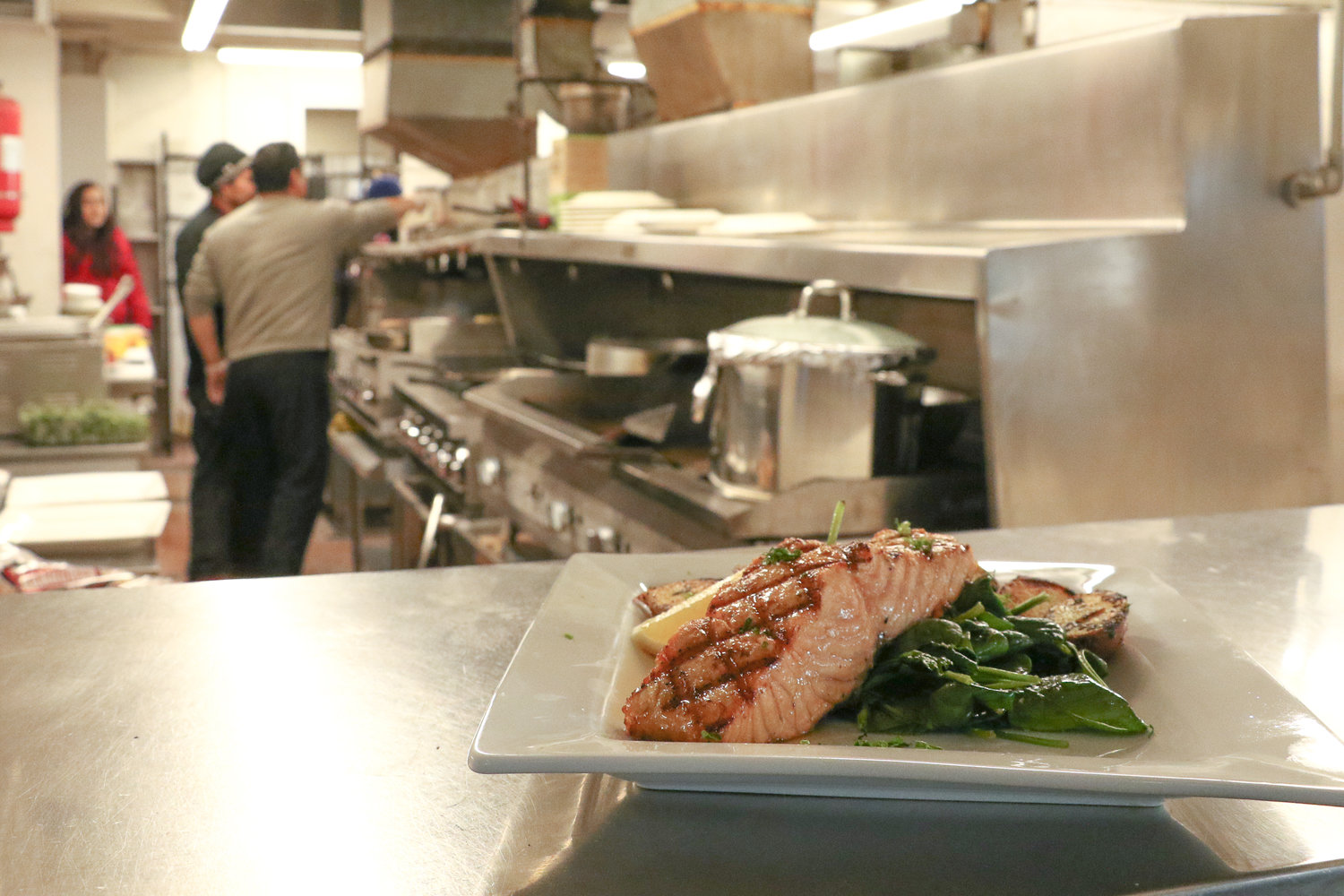 An eight ounce king salmon filet sits atop a bed of sauted spinach after being grilled to perfection by Ocean Prime owner and chef Eyner "Rene" Cardona.