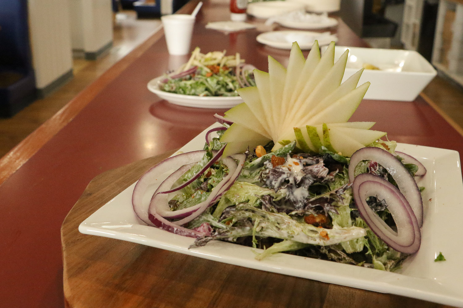 Prepared by Chef Eyner "Rene" Cardona, a bleu cheese salad with candied nuts, red onions and pear slices sits ready to be eaten at a menu sampling for Ocean Prime, Cardona's new restaurant in Chehalis.
