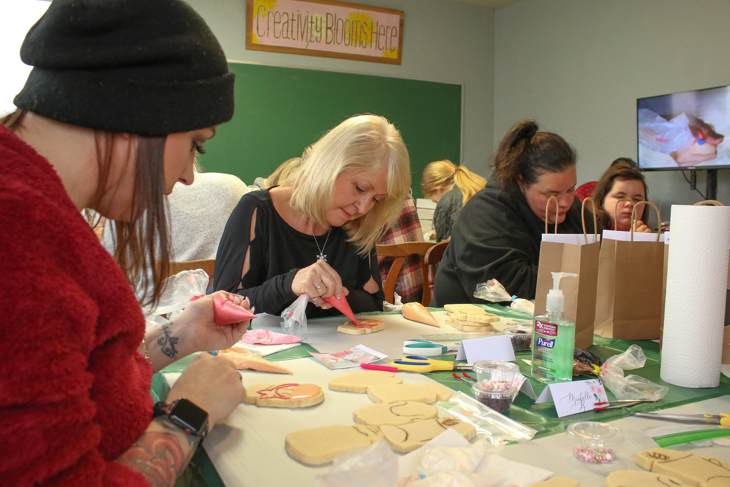 Attendees try their hands at royal icing decorating on sugar cookies during a class taught by Anna Martin at the Dandelion Creative Space on Sunday morning in Chehalis.