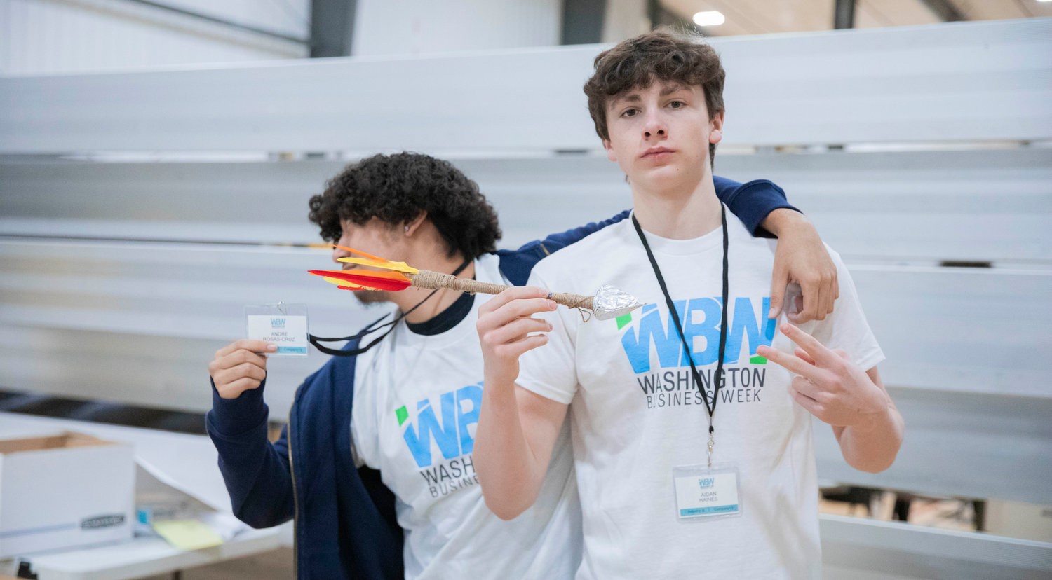 Centralia High School students Andre Rosas-Cruz and Aidan Haines pose for a photo with an arrow created for their company Bullseye Co. during Washington Business Week at the Northwest Sports Hub.