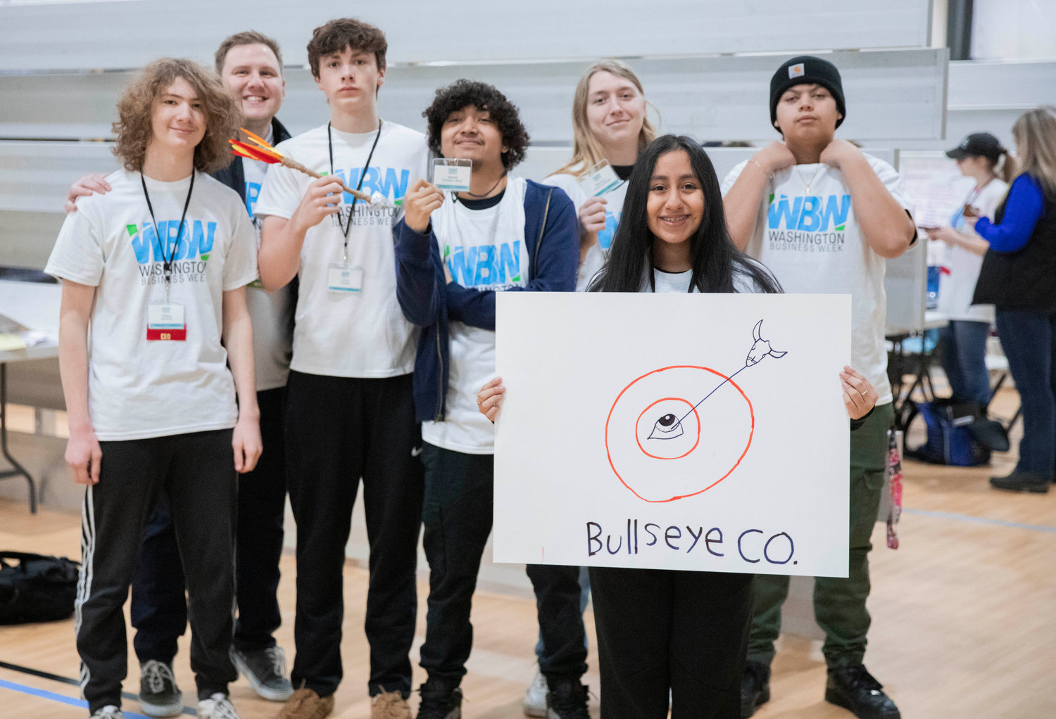 Centralia High School students pose for a photo holding a sign for their company Bullseye Co. during Washington Business Week Wednesday morning at the Northwest Sports Hub.