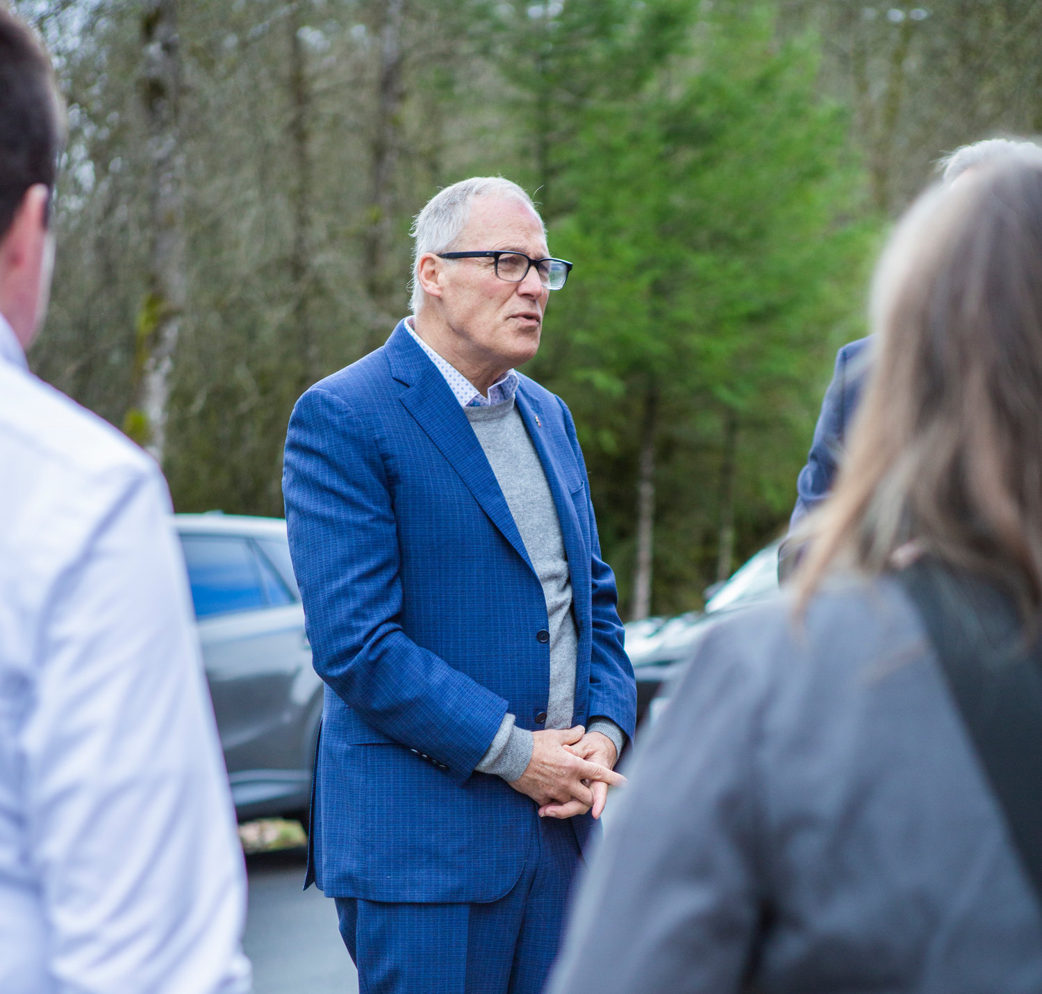 Gov. Jay Inslee speaks with his staff on the grounds of Maple Lane School west of Centralia on Friday, Jan. 27.