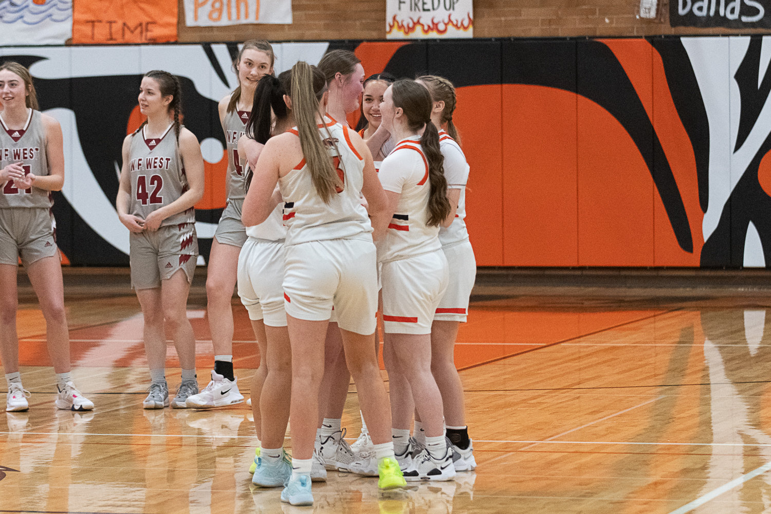 The Centralia girls basketball team embraces senior Gracee Cline as she comes off the court during the Tigers' senior night game against W.F. West on Feb. 1.