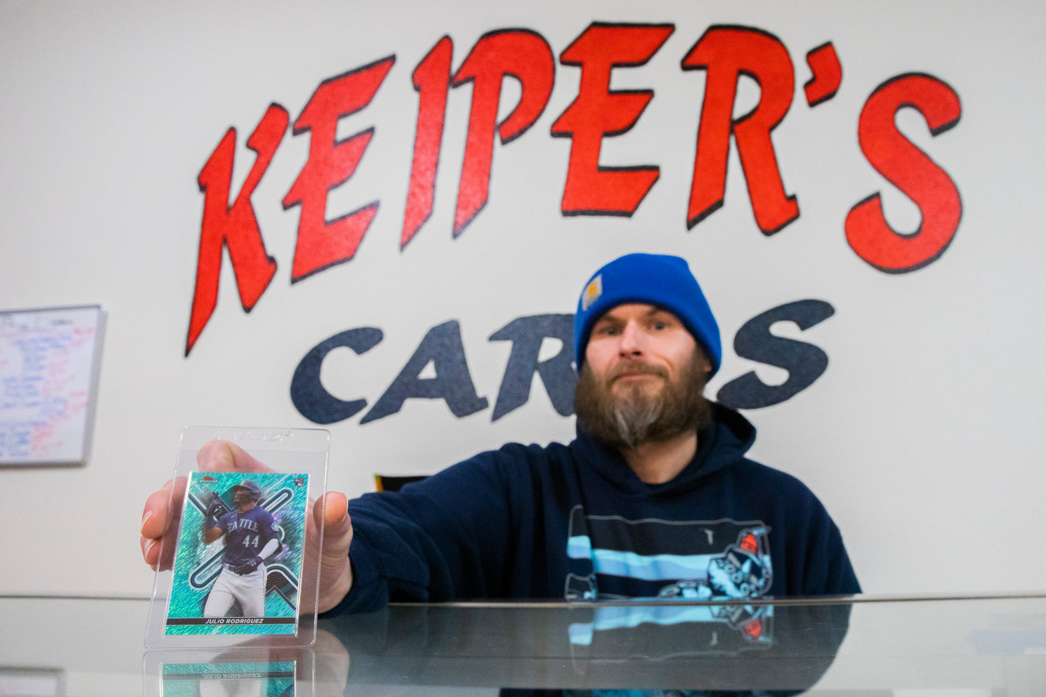 Dan Keiper holds up a Julio Rodriguez card inside Keiper’s Cards in downtown Centralia on Thursday.