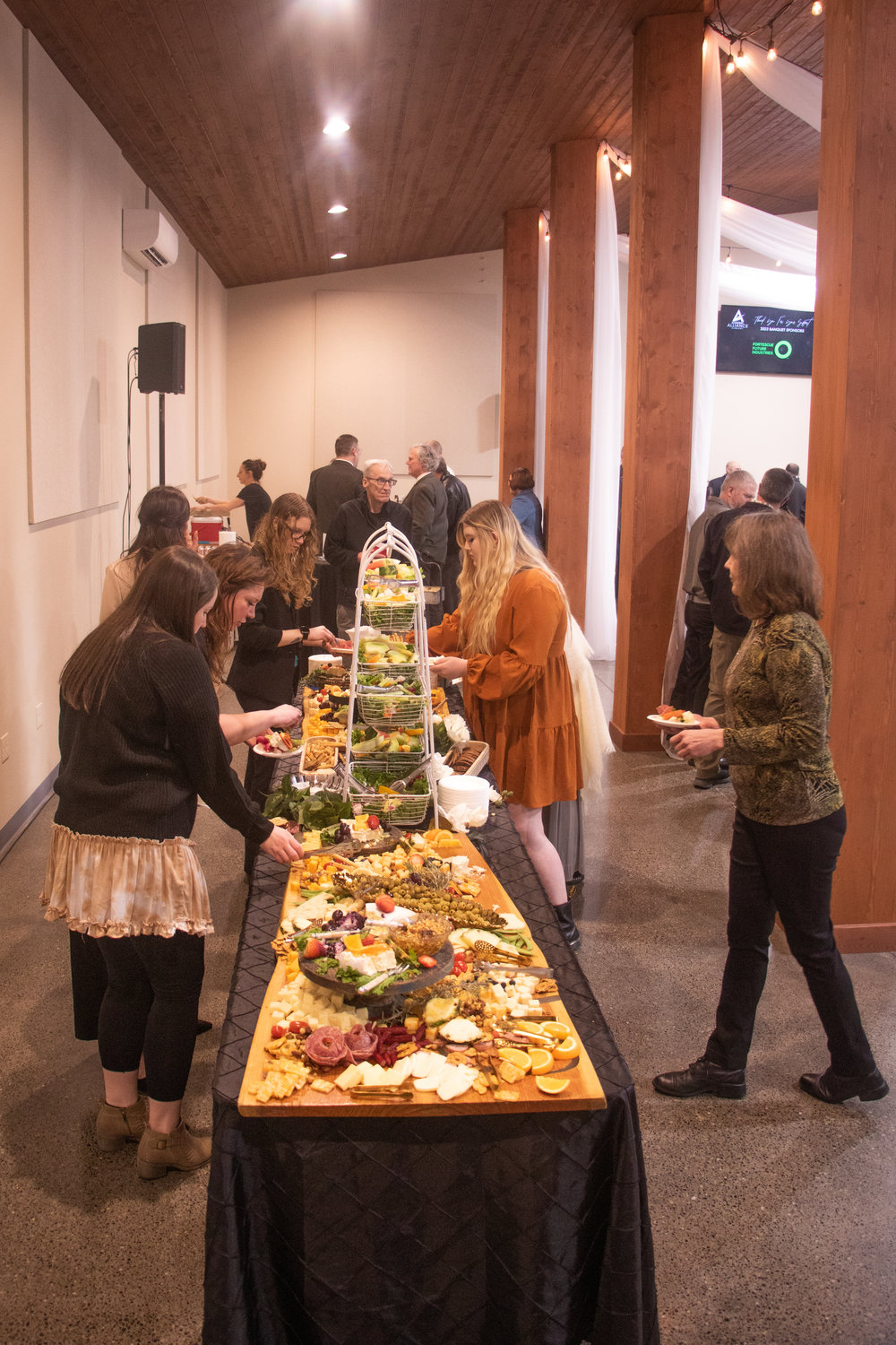 Banquet attendees grab themselves appetizers from the hors d'oeuvre table at the Economic Alliance of Lewis County's 40th annual banquet this past Friday at Jesters Auto Museum & Event Center in Chehalis.