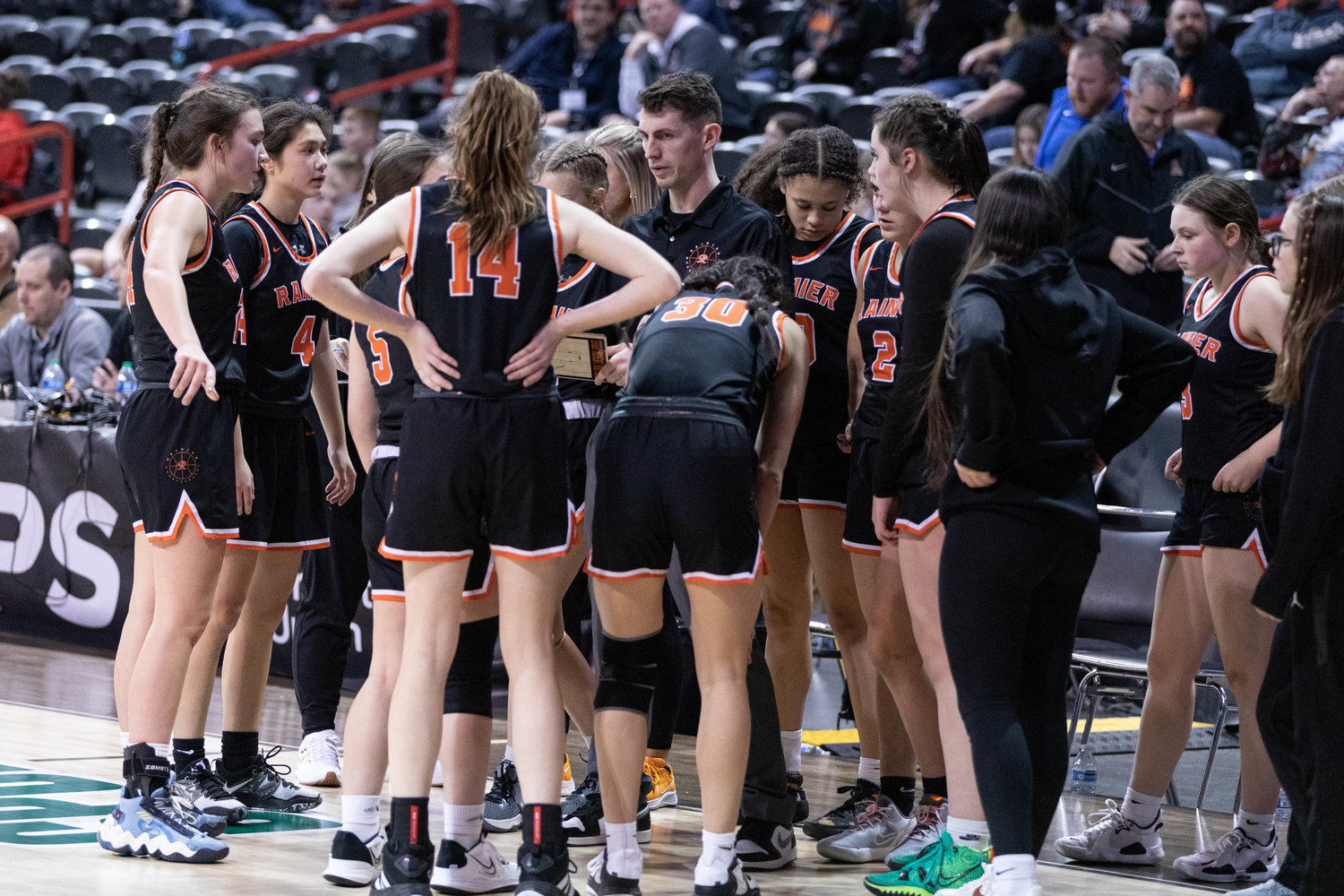 The Rainier girls basketball team huddles during a timeout against Colfax in the 2B state quarterfinals at Spokane Arena March 2.