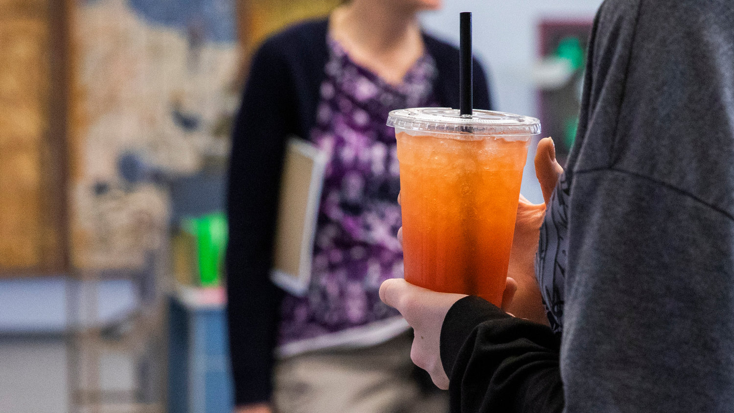 Students at W.F. West High School hold drinks and wait for friends after a ribbon cutting ceremony on Wednesday at a new student store "The Crimson & Gray," powered by Lewis County Coffee Co. in Chehalis.