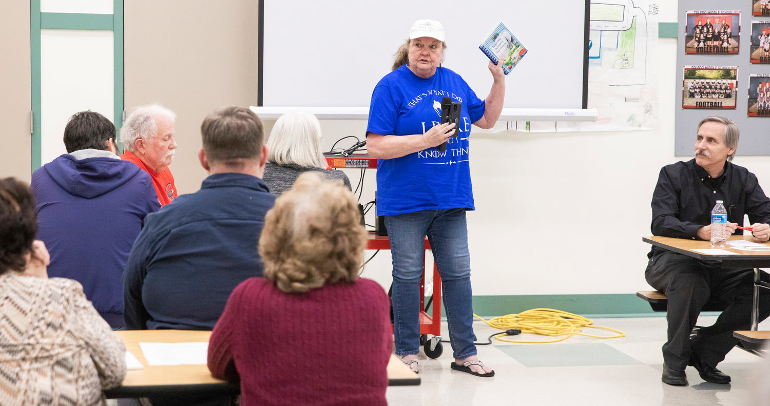 Carol Berch talks about the Toledo Thursday Market while holding up a cookbook titled, “Recipes from the Heart of Toledo, Washington,” during the Big Toledo Community Meeting on Thursday.