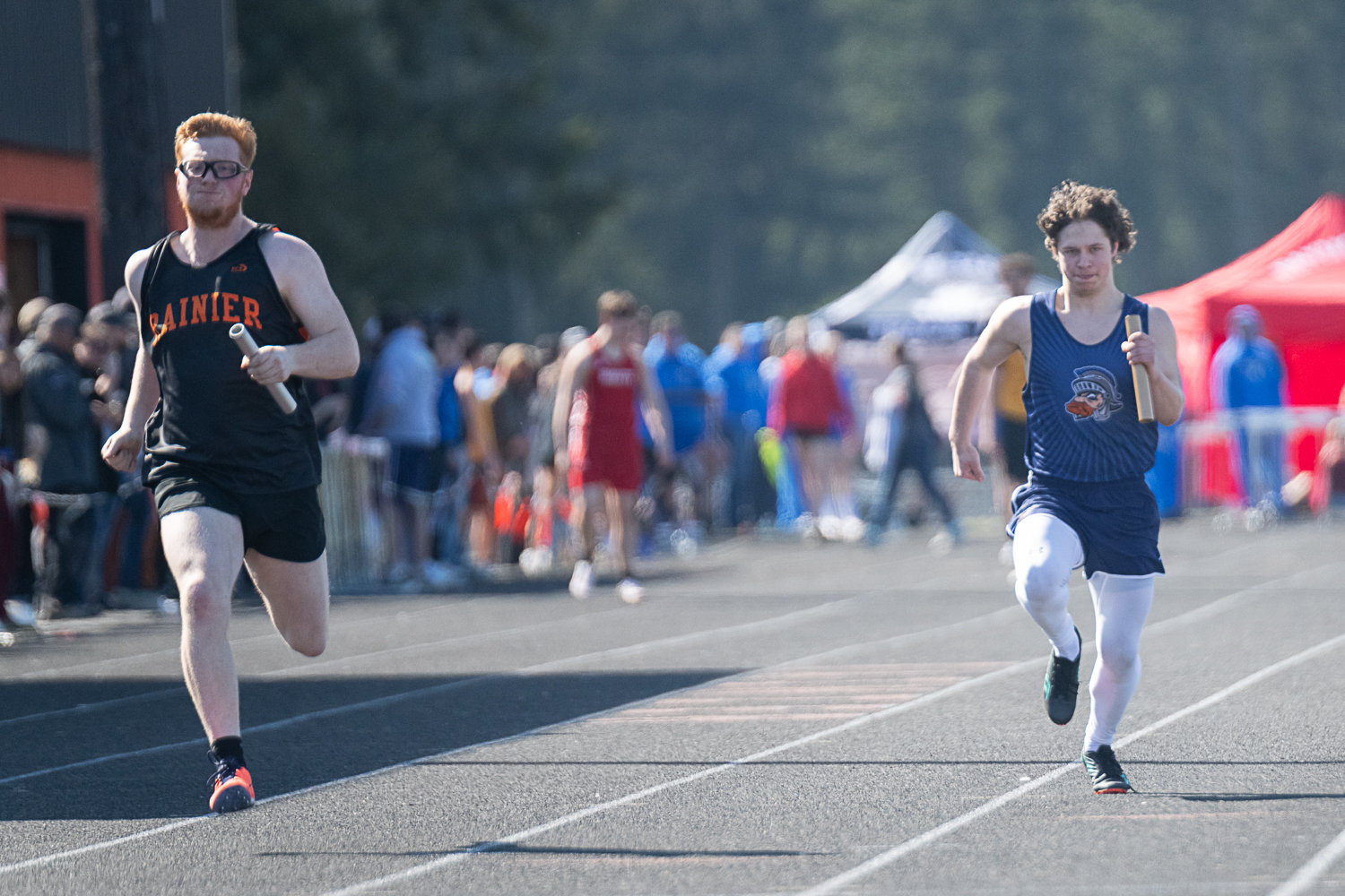 Rainier's Matthew Kenney and Pe Ell's Konnor Pilz come to the finish line in the 4x100 relay at the Rainier Icebreaker on March 18.