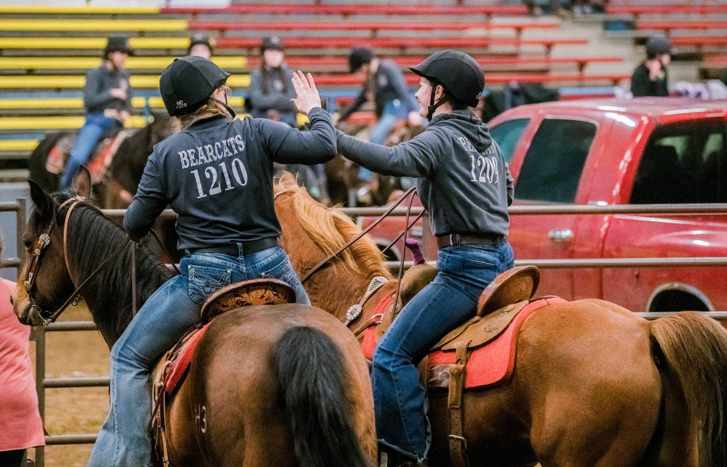 Mossyrock High School seniors Reagan Olson and Josey Majors high-five after a cow sorting event where they competed for the W.F. West High School equestrian team during a district 6 meet on Sunday, March 19 at the Grays Harbor County Fairgrounds.