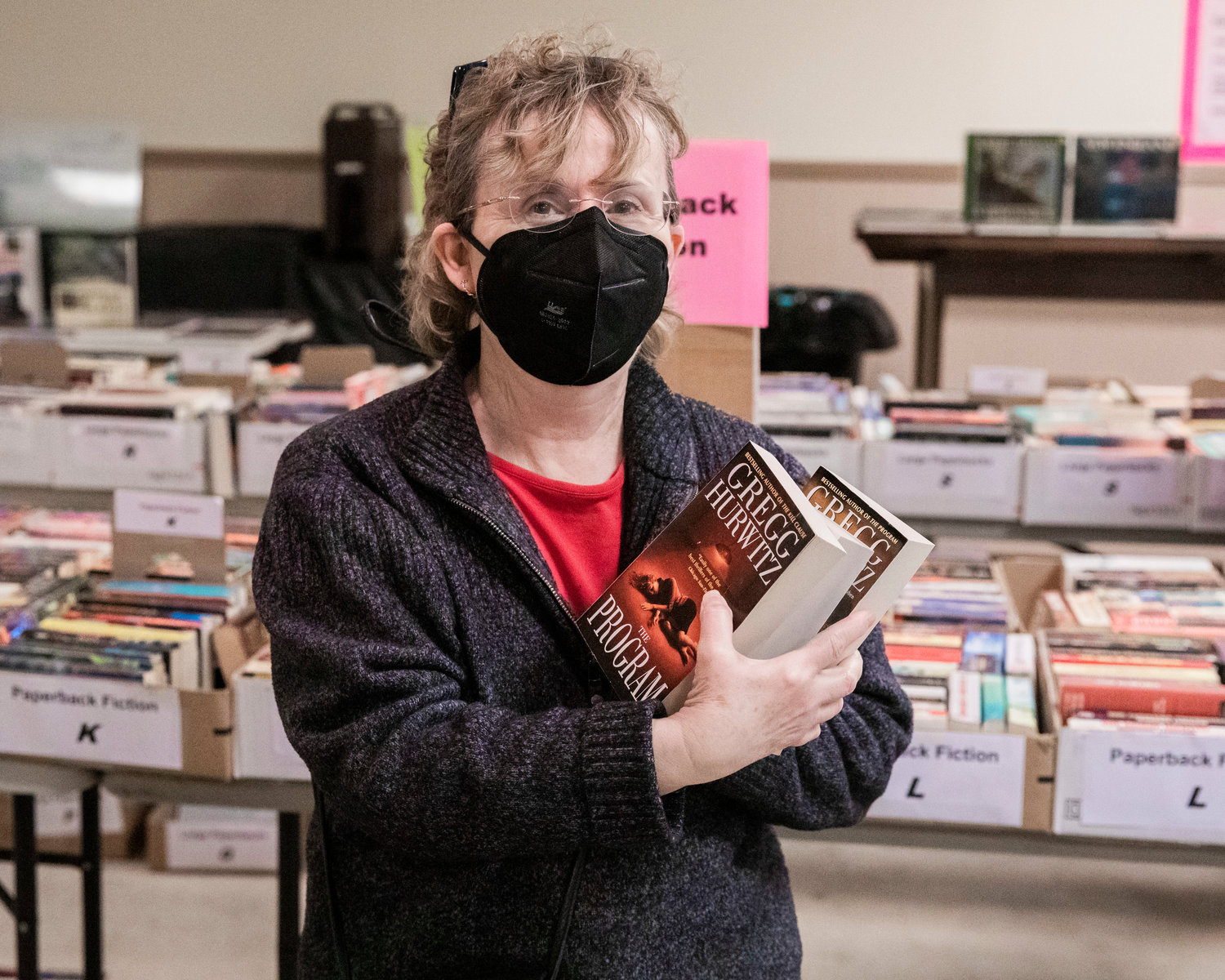 Cathy Cavness holds up books she plans to bring home from the AAUW Used Book Sale at the Moose Lodge in Centralia on Tuesday.