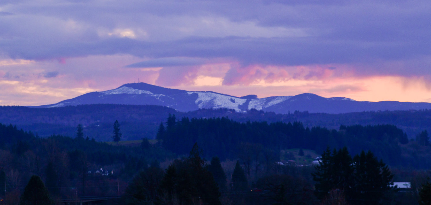 The sun sets over the snowy Willapa Hills Tuesday evening seen from Chehalis.