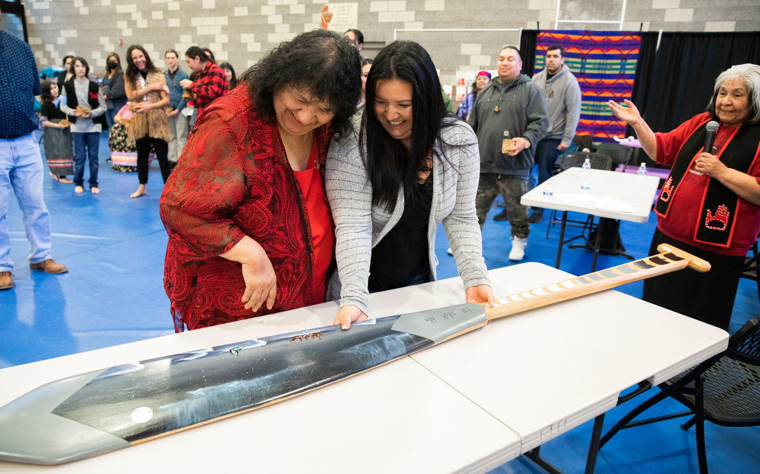 Trudy Marcellay, left, smiles after being being gifted a hand painted oar from Artist and New Master Weaver Jeycee Zepeda during a ceremony honoring the Hazel Pete legacy at the Chehalis Tribe Community Center in Oakville on Saturday.