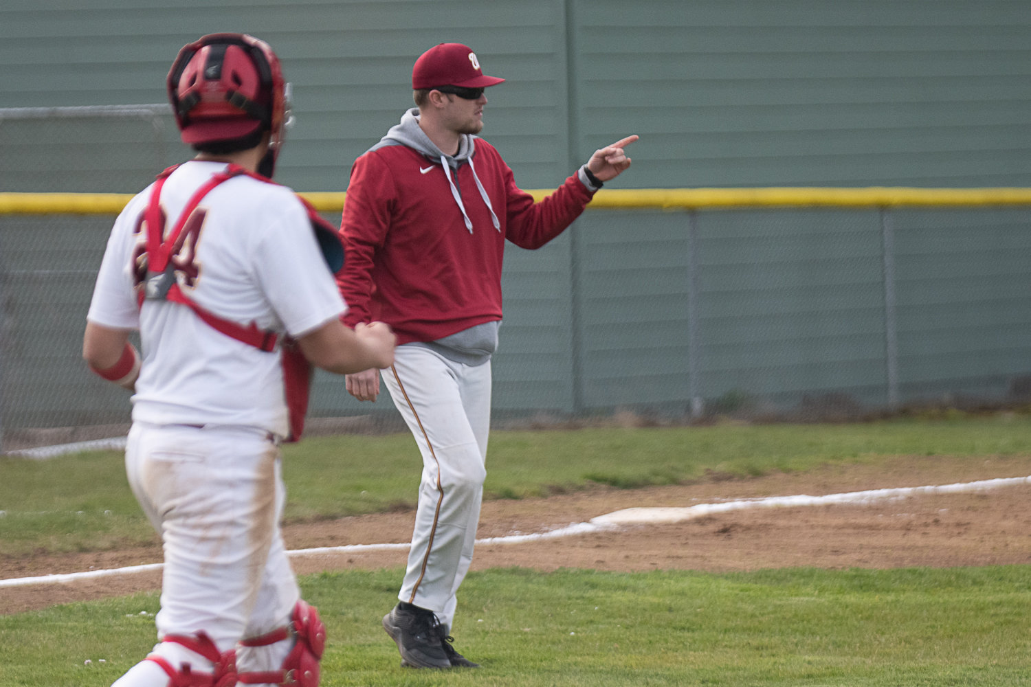Winlock coach Cole Doughty makes a call to the bullpen during the Cardinals' first game against Morton-White Pass on March 27.