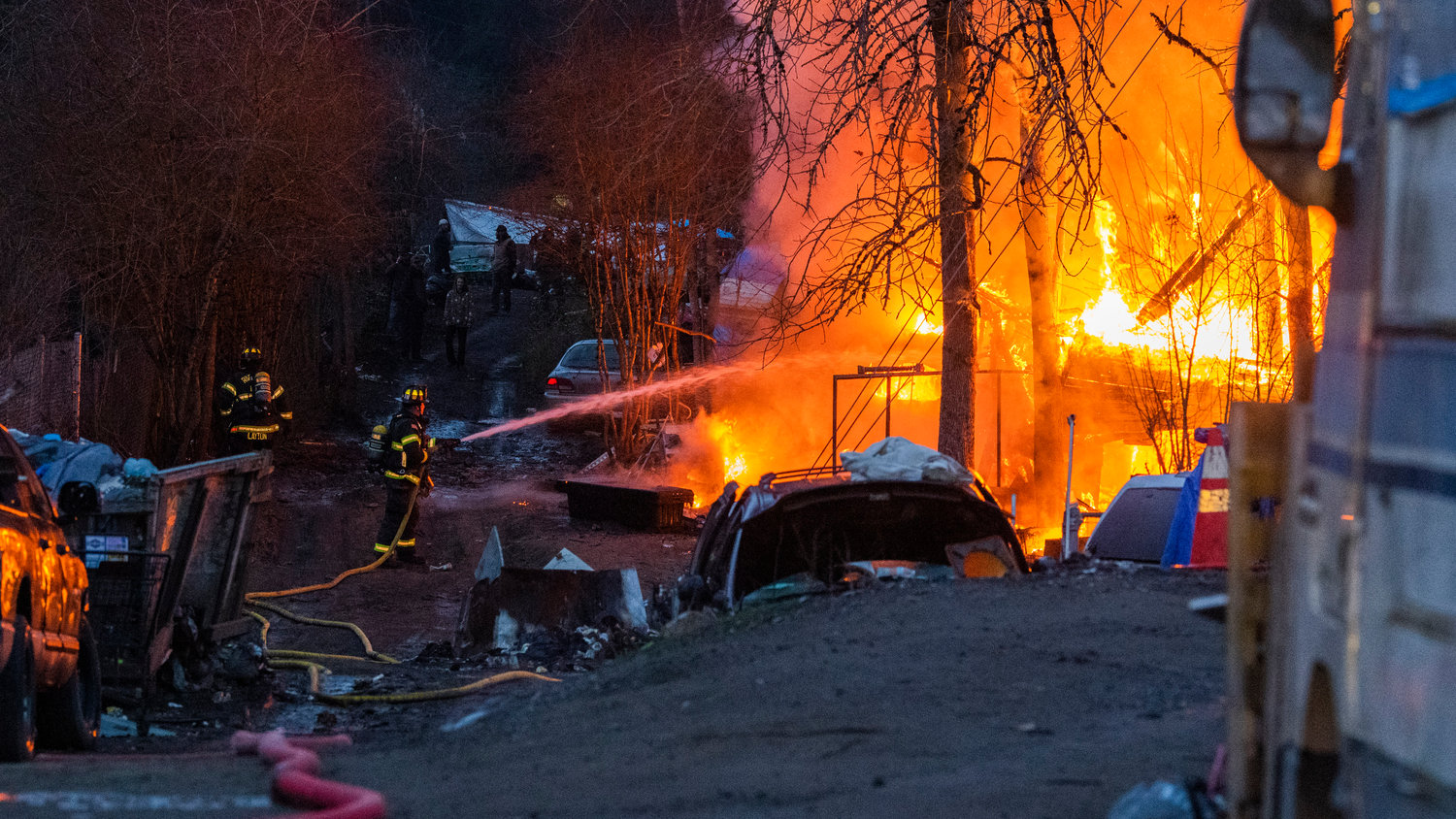 Riverside Fire Authority, Centralia police and the Chehalis Fire Department respond to a scene at the end of Eckerson Road in Centralia near Blakeslee Junction where flames and a column of smoke rose from a structure inside a homeless encampment Tuesday, March 28, 2023.