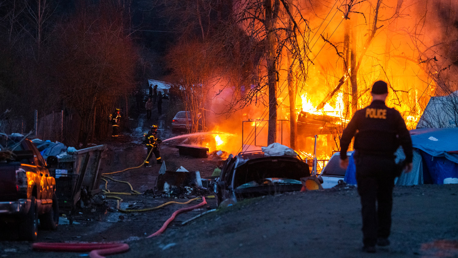 Riverside Fire Authority, Centralia police and the Chehalis Fire Department respond to a scene at the end of Eckerson Road in Centralia near Blakeslee Junction where flames and a column of smoke rose from a structure inside a homeless encampment Tuesday, March 28, 2023.