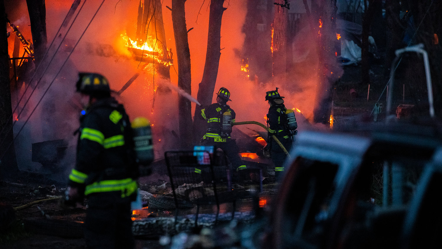 Firefighters battle flames at the end of Eckerson Road in Centralia near Blakeslee Junction as smoke and heat billows from a structure inside a homeless encampment Tuesday, March 28, 2023.