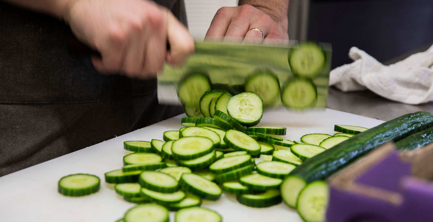 Carson Lotton chops cucumbers to make spicy pickles at The Juice Box in downtown Centralia Tuesday morning.