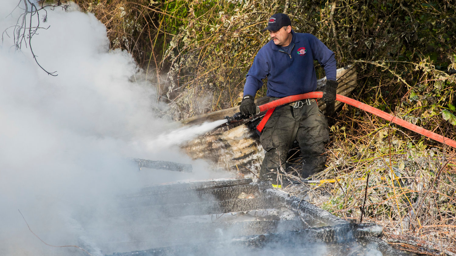 Crews from Riverside Fire Authority use hoses to extinguish flames that destroyed an outbuilding that was supposed to be unoccupied along Long Road in Centralia Thursday morning.