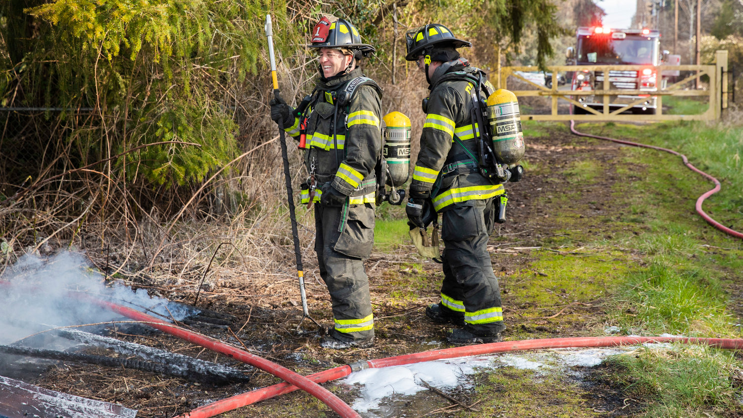 Captain Casey McCarthy, with Riverside Fire Authority, smiles after flames were controlled at an outbuilding that was supposed to be unoccupied along Long Road in Centralia Thursday morning.