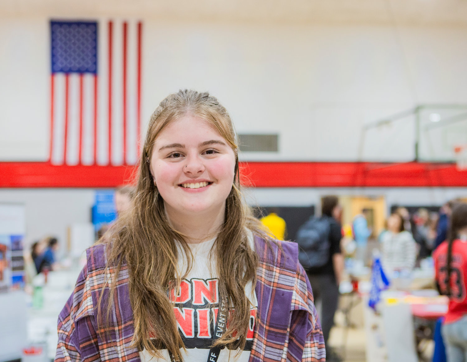 Tenino High School student Holly Thoren, the lead organizer of the school’s college and career fair, smiles in the gymnasium on Thursday morning as students flock to tables with recruiters and educators.