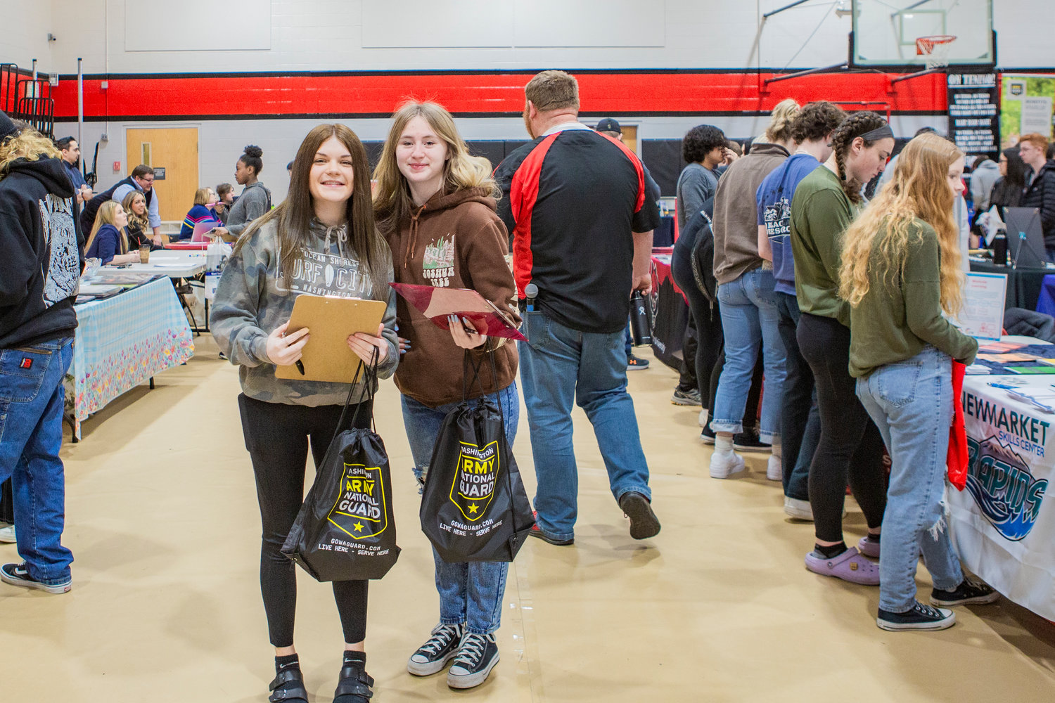 Tenino High School students smile Thursday morning as students flock to tables with recruiters and educators during a college and career fair.