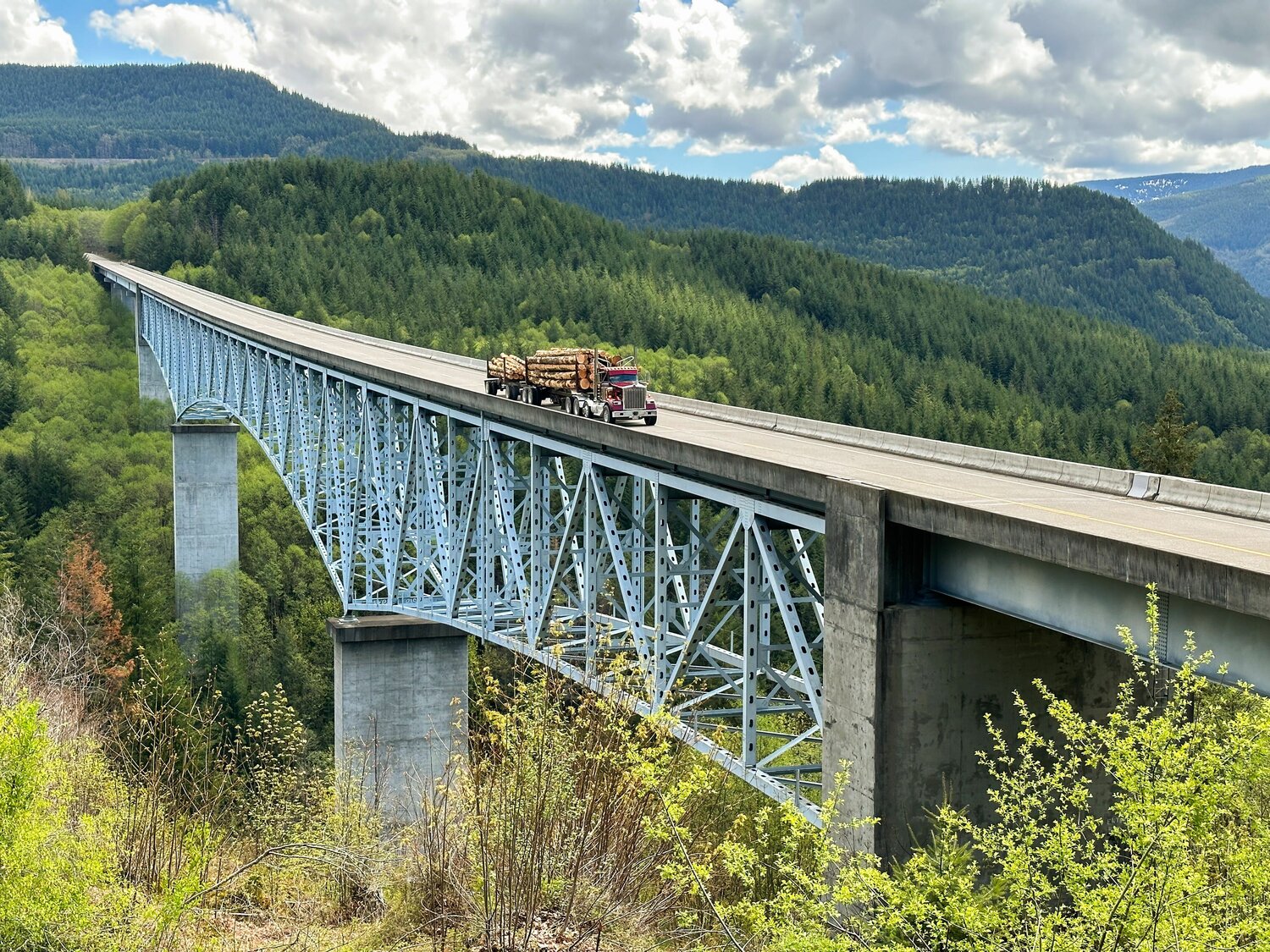 A log truck crosses the Hoffstadt Creek Bridge along Spirit Lake Highway on Thursday, May 11.