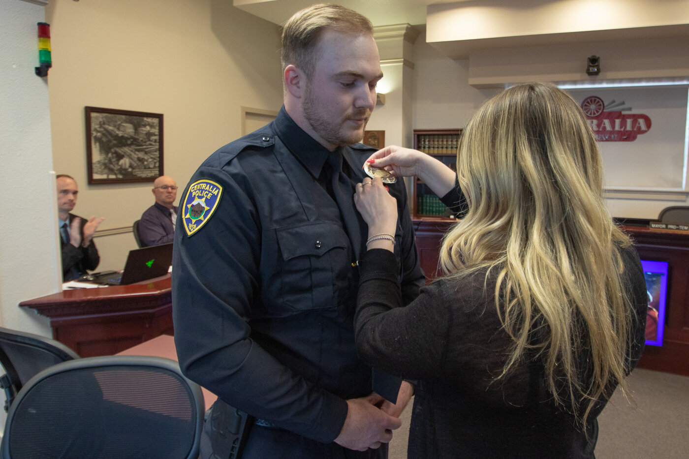 Following being sworn in, Officer August Shulda has his badge pinned on by his girlfriend, Julia Morasch.