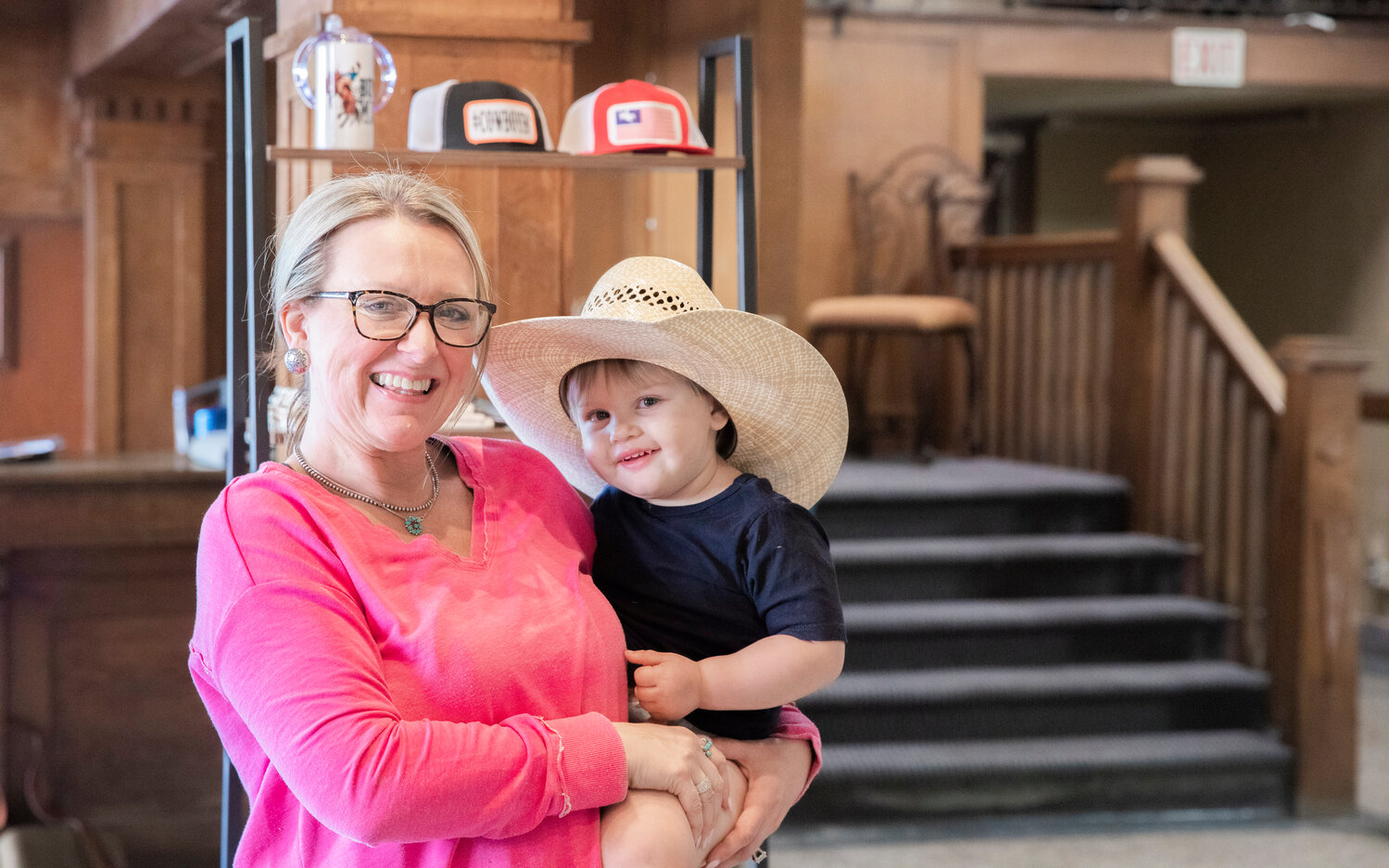 Jeannie Gluck, owner of Saddle Bum, smiles for a photo with Porter Fay, 2, inside her Centralia business on Monday, May 8.