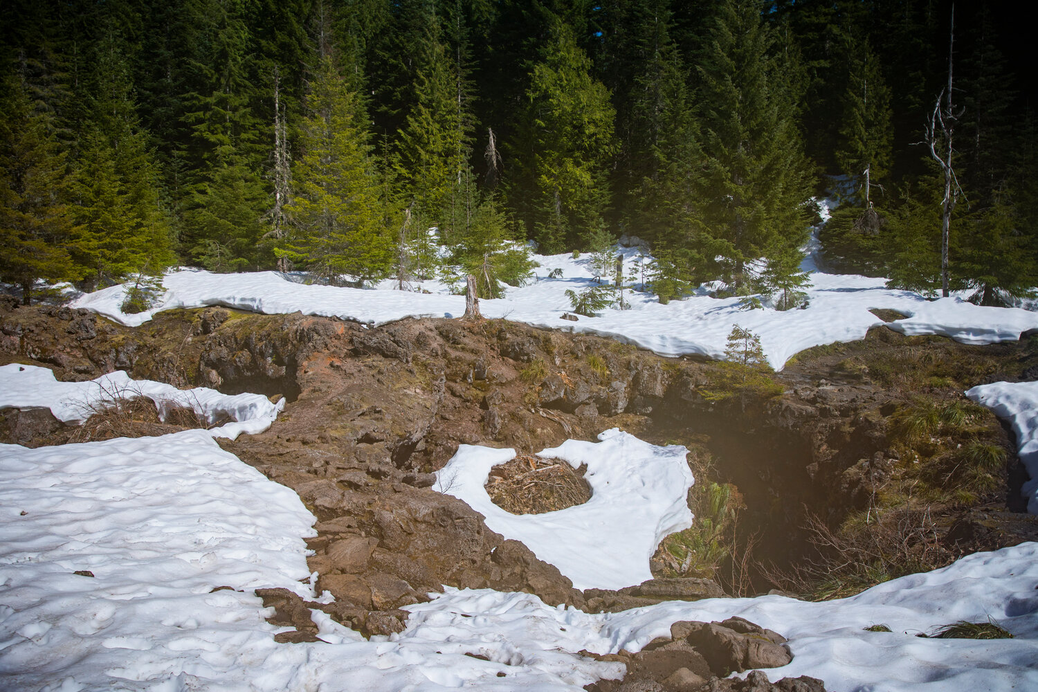 Snow blankets the ground around the upper entrance to the Ape Cave Interpretive Site in Cougar on opening day Thursday, May 18.