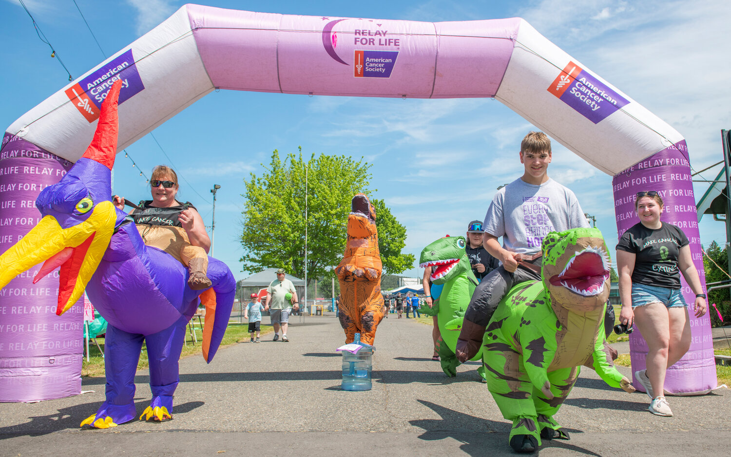 Inflatable dinosaurs make their way through a Relay For Life arch while supporting a survivor walk to “make cancer extinct” at the Southwest Washington Fairgrounds on Saturday, May 20.