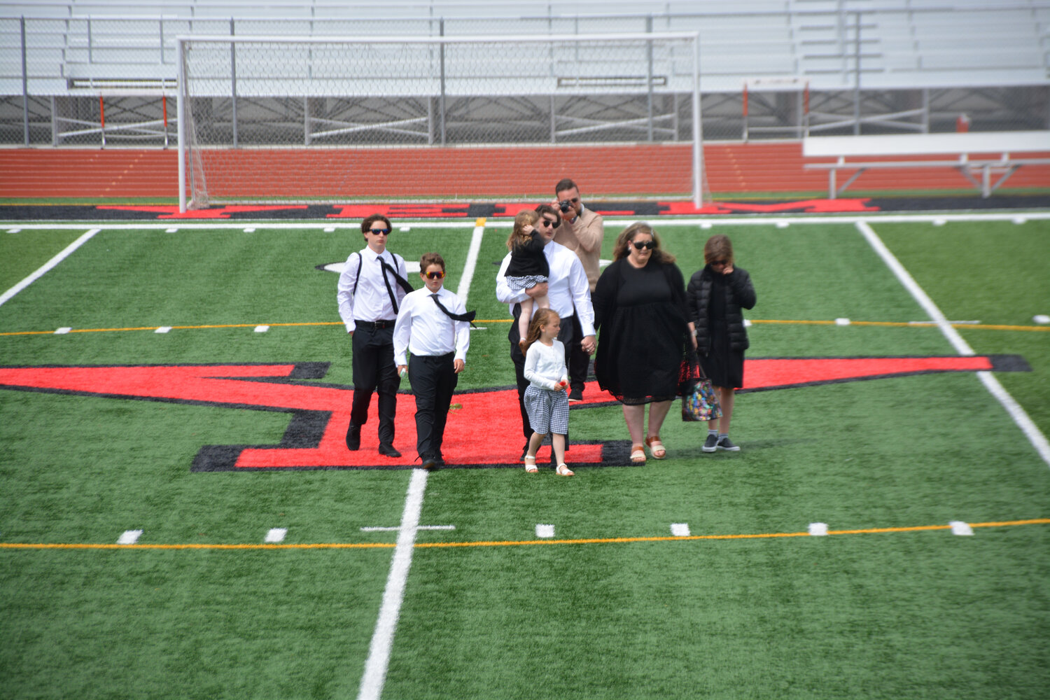 The Jemtegaard family leaves mid-field, where they left roses in honor of their late father and husband.