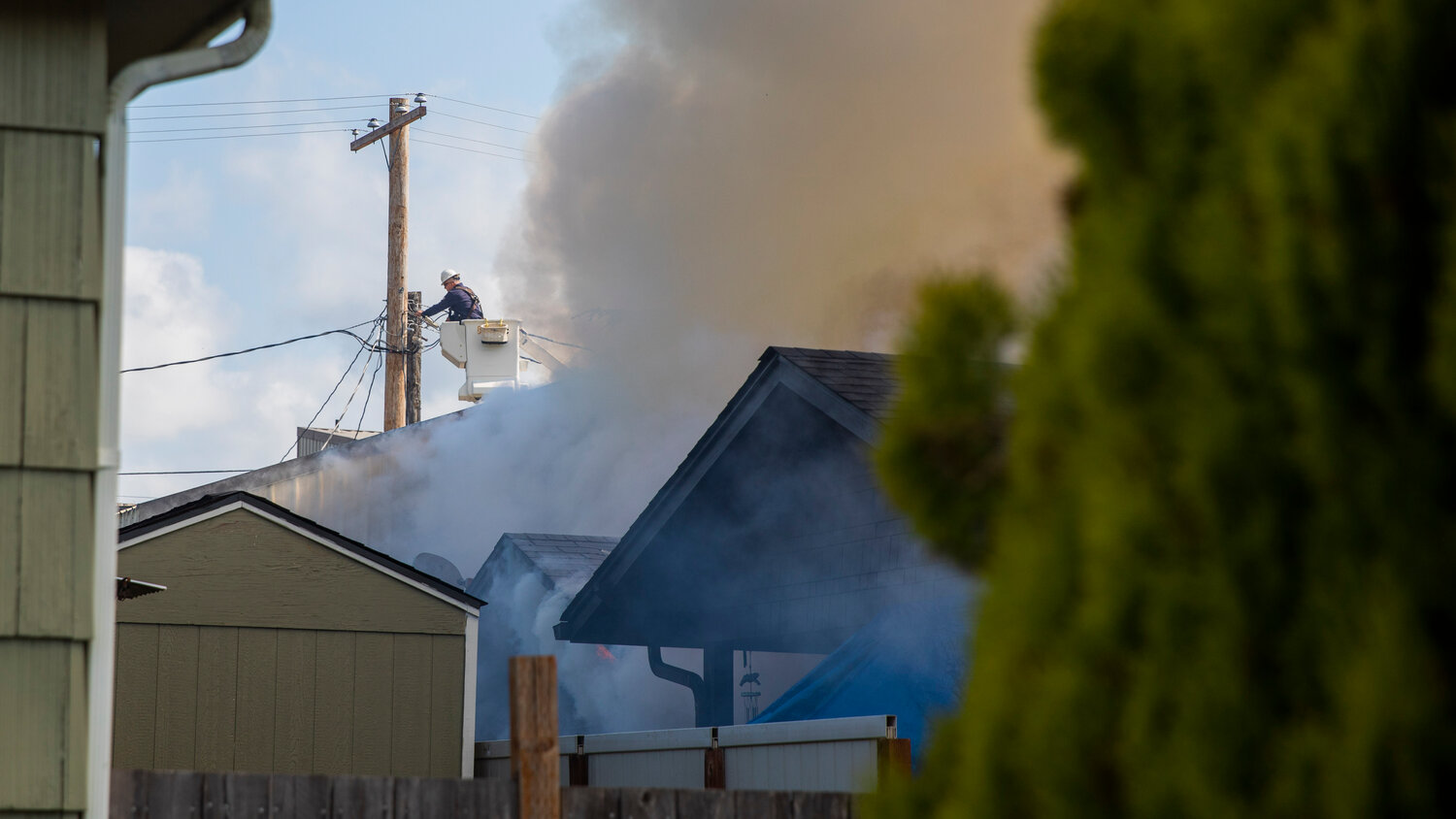 Crews work to cut power to a residence during a fire in the 800 block of Centralia College Blvd. on Wednesday, May 24.