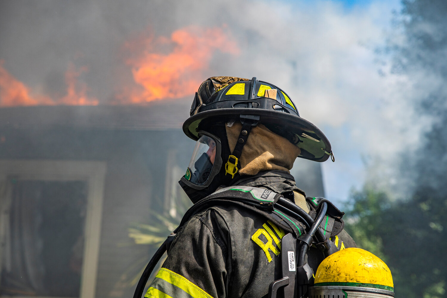 A Riverside firefighter looks on as smoke and flames consume a residence in the 800 block of Centralia College Blvd. on Wednesday, May 24.