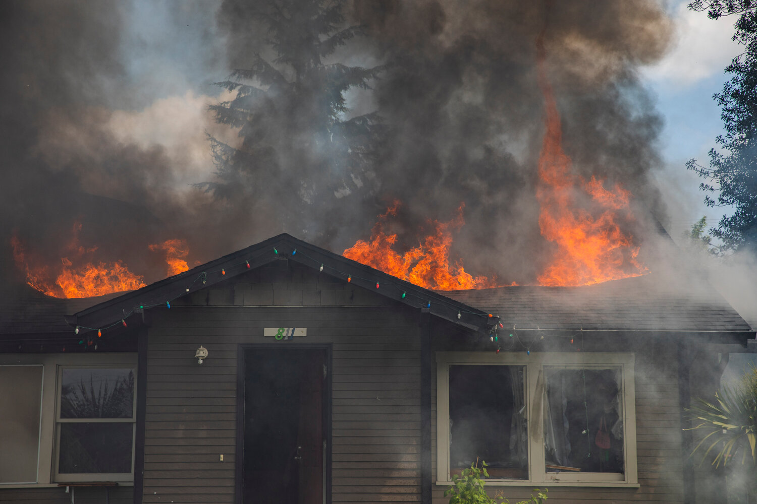 Flames and a column of smoke rise from a residence in the 800 block of Centralia College Blvd. on Wednesday, May 24.