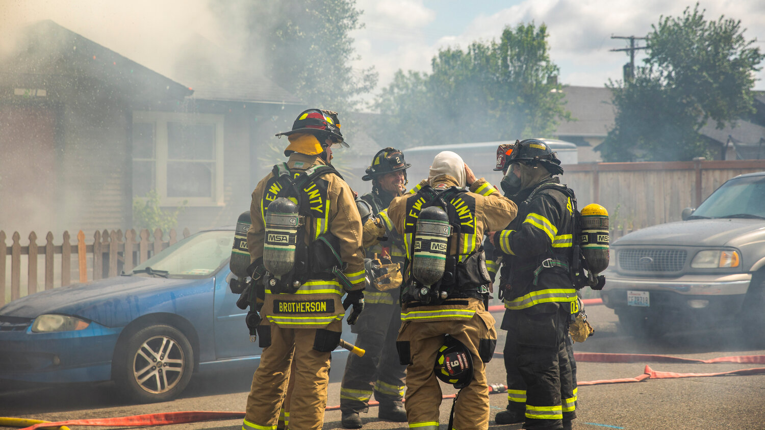 Lewis County and Riverside firefighters organize as they work to put out flames at a residence in the 800 block of Centralia College Blvd. on Wednesday, May 24.