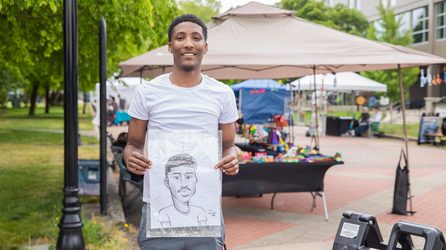 Tre Frazier smiles for a photo with a caricature by Sam Arneson during Spring Fest at Centralia College on Tuesday, May 23. The annual event, which is open to Centralia College students at no cost, continues from 10 a.m. to 2 p.m. Thursday on the plaza and esplanade.