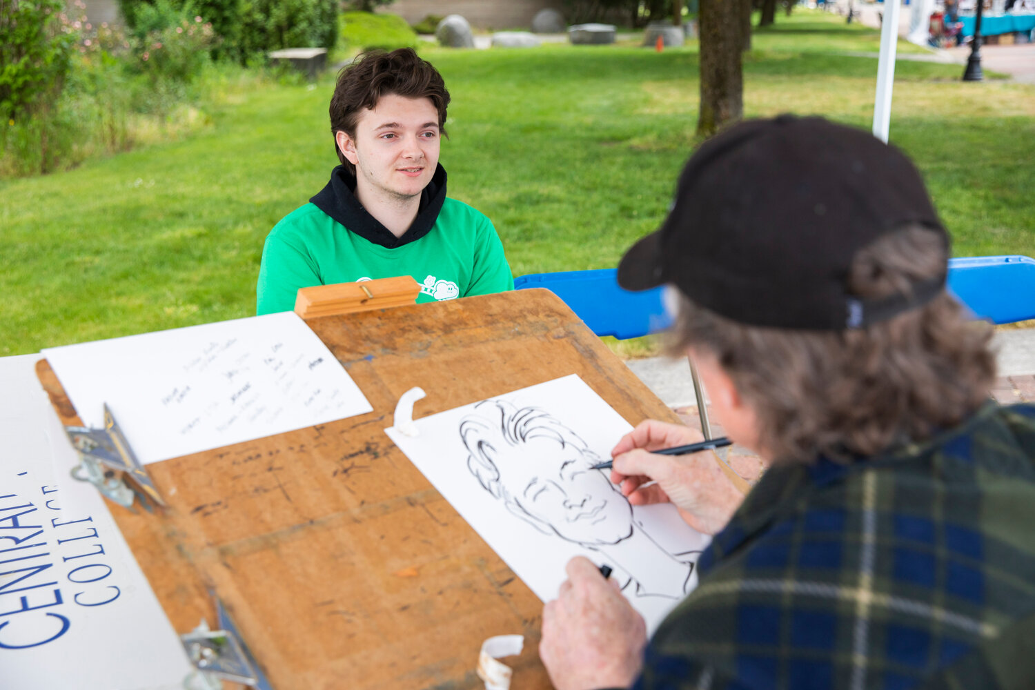 Visitors sit as caricatures are created during Spring Fest at Centralia College on Tuesday, May 23. The annual event, which is open to Centralia College students at no cost, continues from 10 a.m. to 2 p.m. Thursday on the plaza and esplanade.