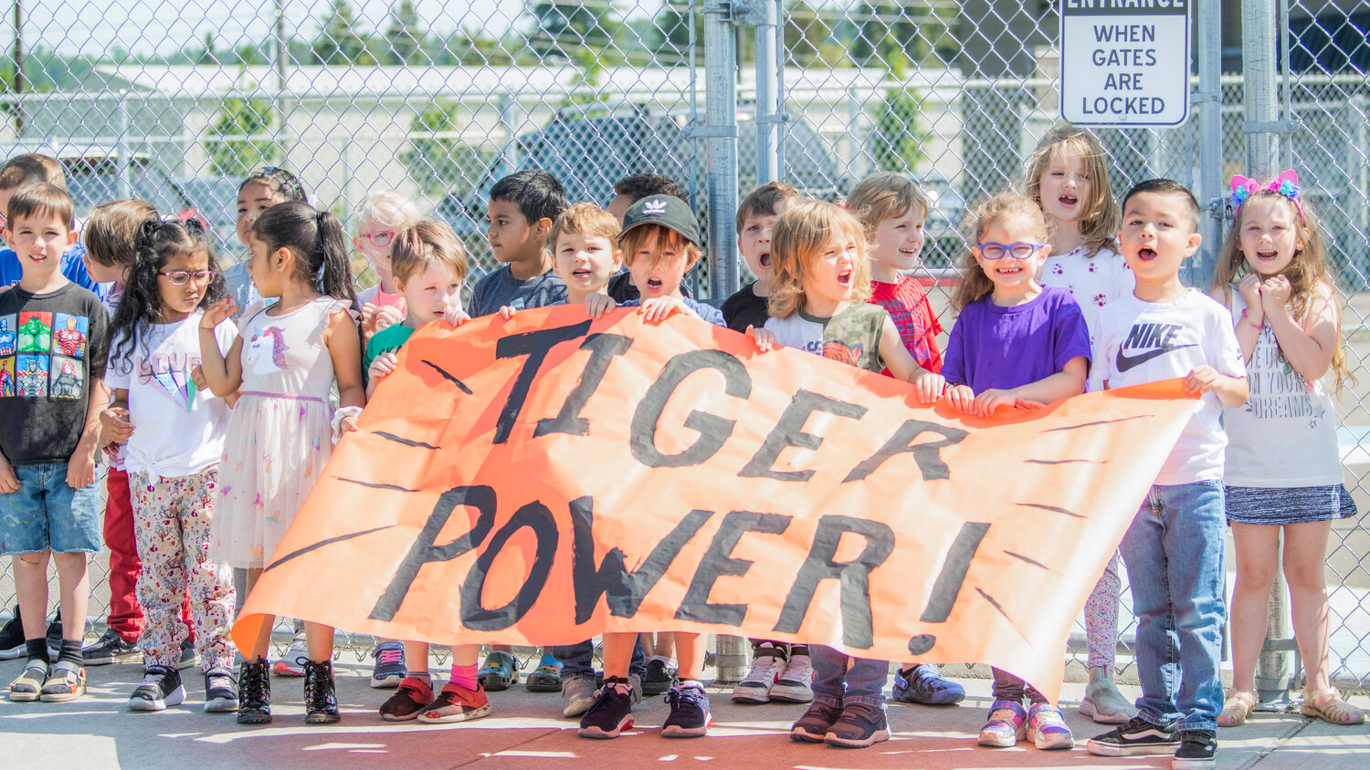 Elementary school students in Centralia hold up a “Tiger Power” sign for the state-bound high school softball team on Thursday morning.