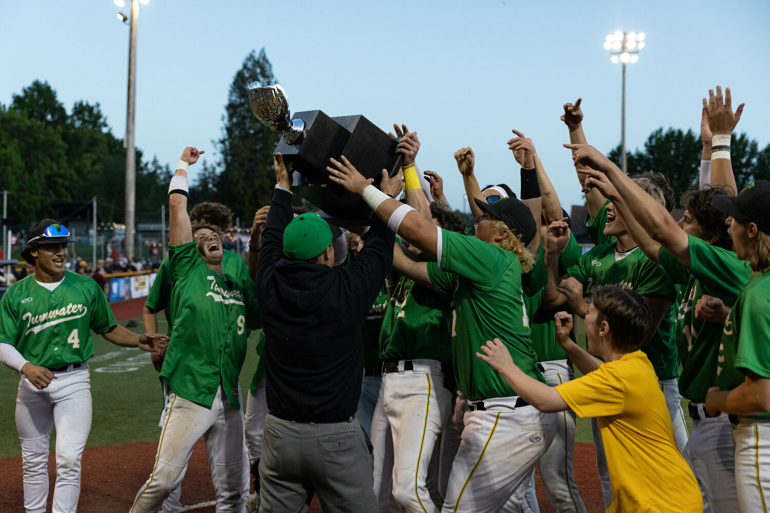 Tumwater athletic director Tim Graham hands the first-place trophy to the T-Bird baseball team after a 2-1 win in the 2A state title against Lynden at Joe Martin Stadium in Bellingham May 27.